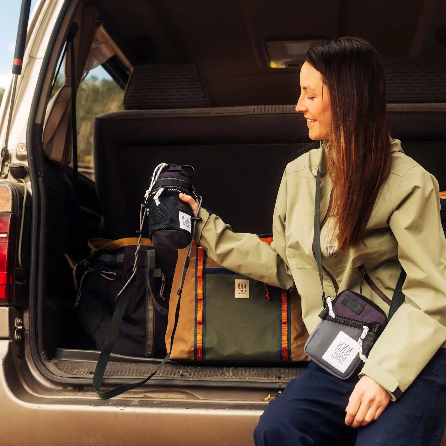 Torba Uchwyt na butelkę Mountain Hydro Sling – Topo Designs modelka w samochodzie