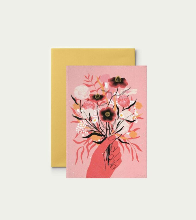 Kartka na życzenia z motywem bukietu trzymanego w dłoni Na różowym tle kwiaty w kolorach białym czarnym żółtym i ciemnoróżowym